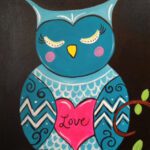 A Starry Night Kitty sitting on a branch with a heart on it.