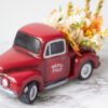 A red truck with flowers sitting on a marble table.