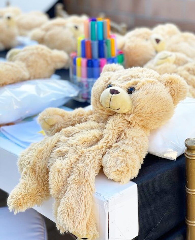 Teddy bears with markers at a party venue.