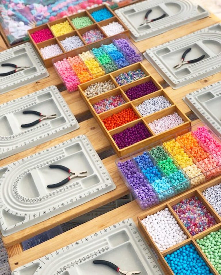 A table full of colorful beads on a wooden table.