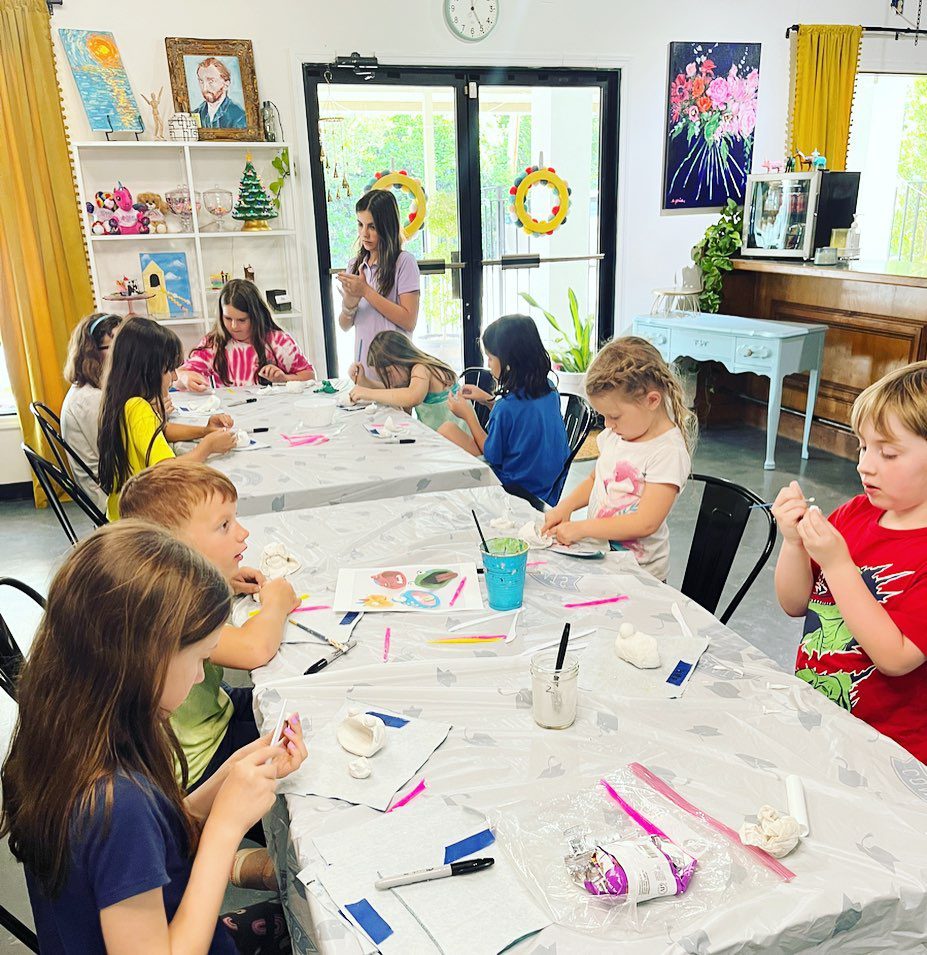 A group of children are sitting at a table making crafts.