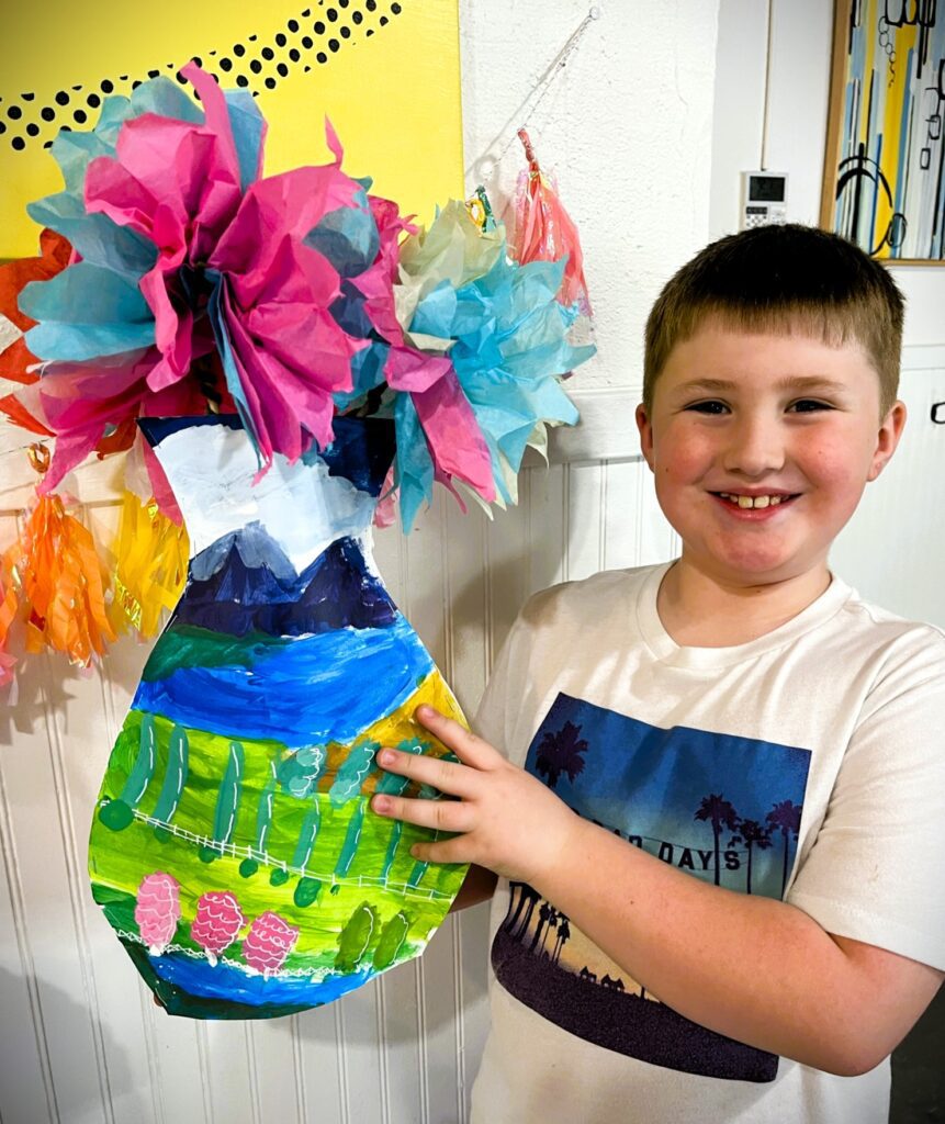 boy showing off art project