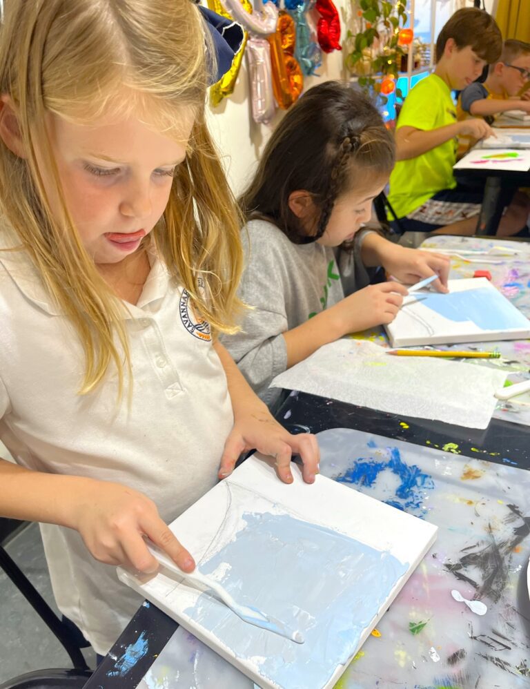 girl working on art at a table