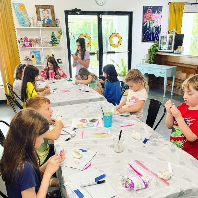 A group of children are sitting at a table making crafts.