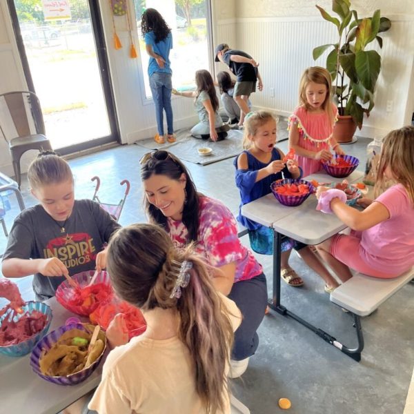 A group of children sitting around tables with baskets.
