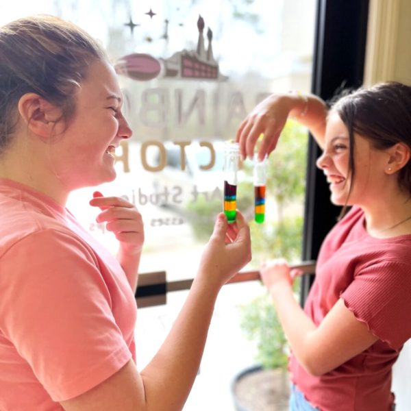 Two girls standing in front of a glass door.